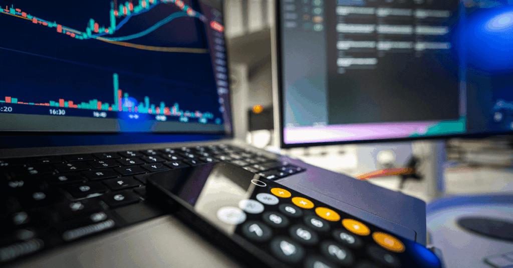 Tela de computador com gráfico de investimentos e calculadora, representando análise de fundos imobiliários.